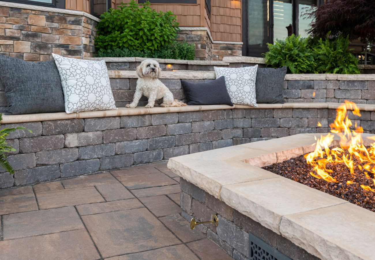 Dog Sitting on Unilock Multi-Level Retaining Wall surrounding Outdoor Fire Pit