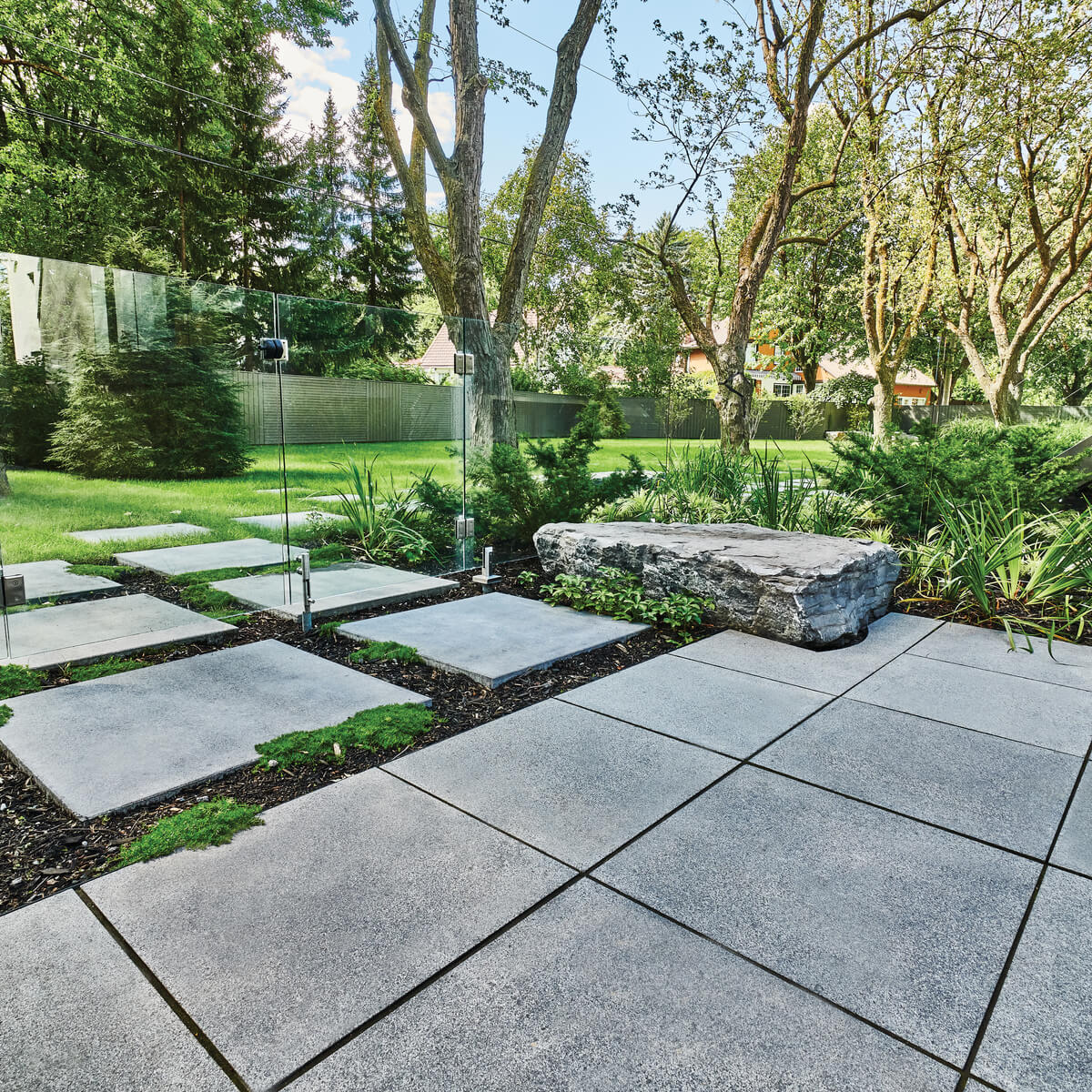 A backyard transformed by Unilock large concrete patio pavers and slabs