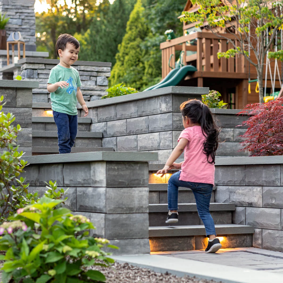 Children Walking on Unilock Steps with Lighting and Multi-Level Retaining Walls