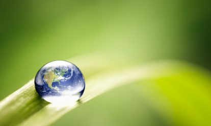 A rain droplet resembling the Earth on a leaf.